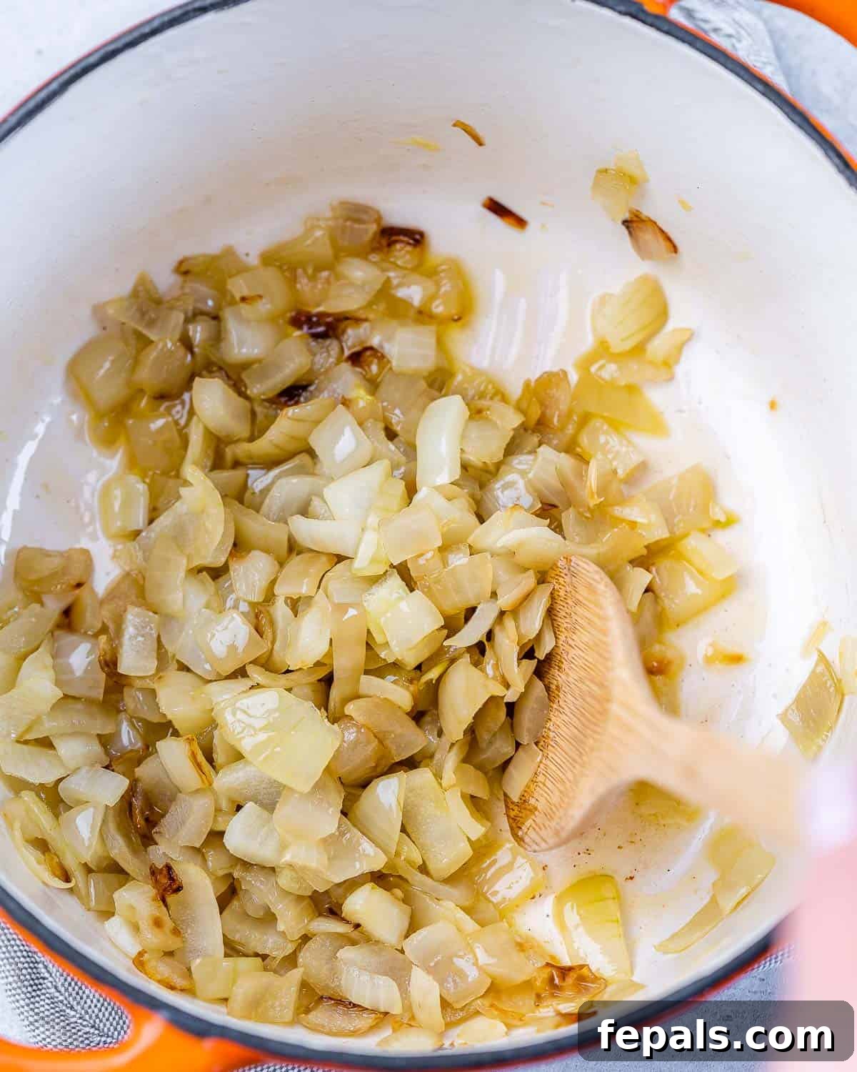 Savory Chickpea and Vegetable Simmer 5 Sautéing diced onions in a large Dutch oven until softened and golden brown, illustrating the first step of the stew recipe.