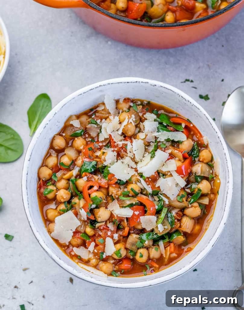 Savory Chickpea and Vegetable Simmer 9 A top-down view of a white, round bowl filled with vegetarian chickpea stew, garnished with fresh herbs and a hint of steam rising, emphasizing its warmth and inviting nature.