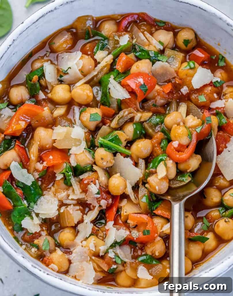 Savory Chickpea and Vegetable Simmer 10 A top-down view of a white bowl filled with the hearty chickpea stew, a spoon dipped in, highlighting the rich texture and inviting steam.