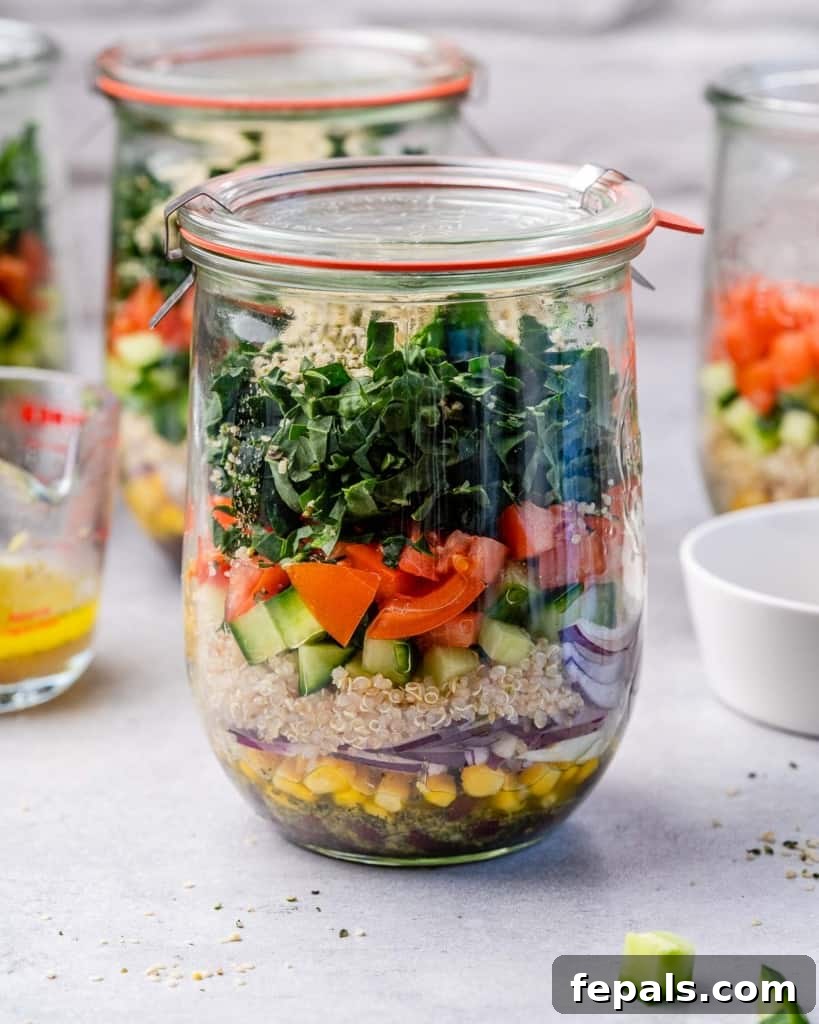 Tuscan Kale Power Jar 2 A vibrant Italian Kale Salad layered in a glass jar, featuring quinoa, kale, tomatoes, and cucumbers.