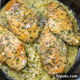 top view of chicken breasts in a garlic butter sauce in a round black skillet