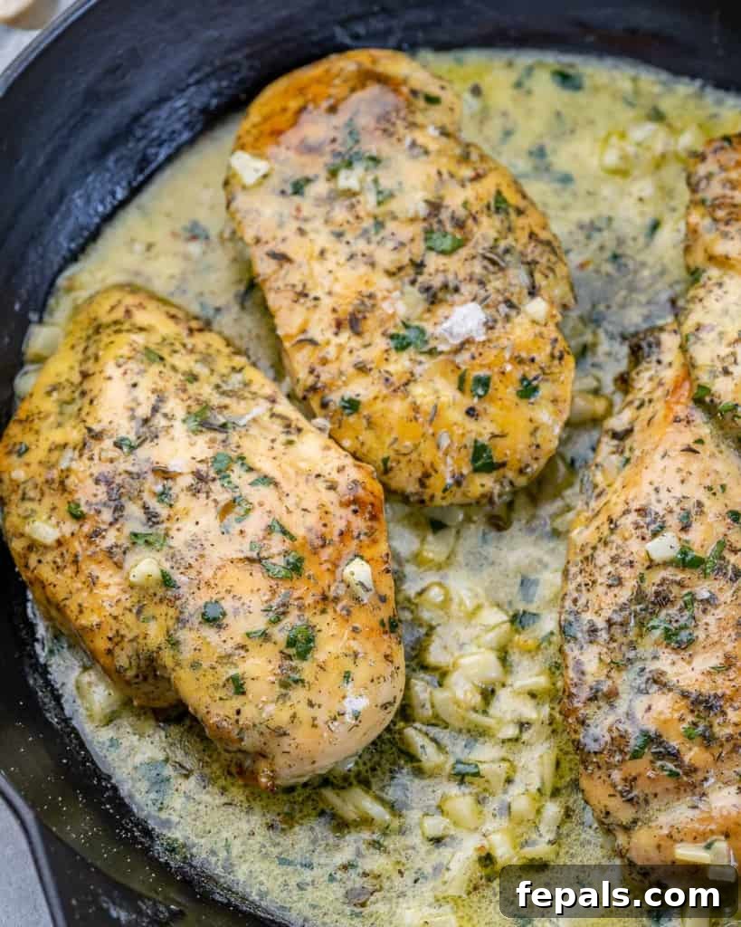 Pieces of chicken cooking in a buttery sauce.