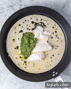 Adding cream cheese, pesto and almond milk to a large skillet.