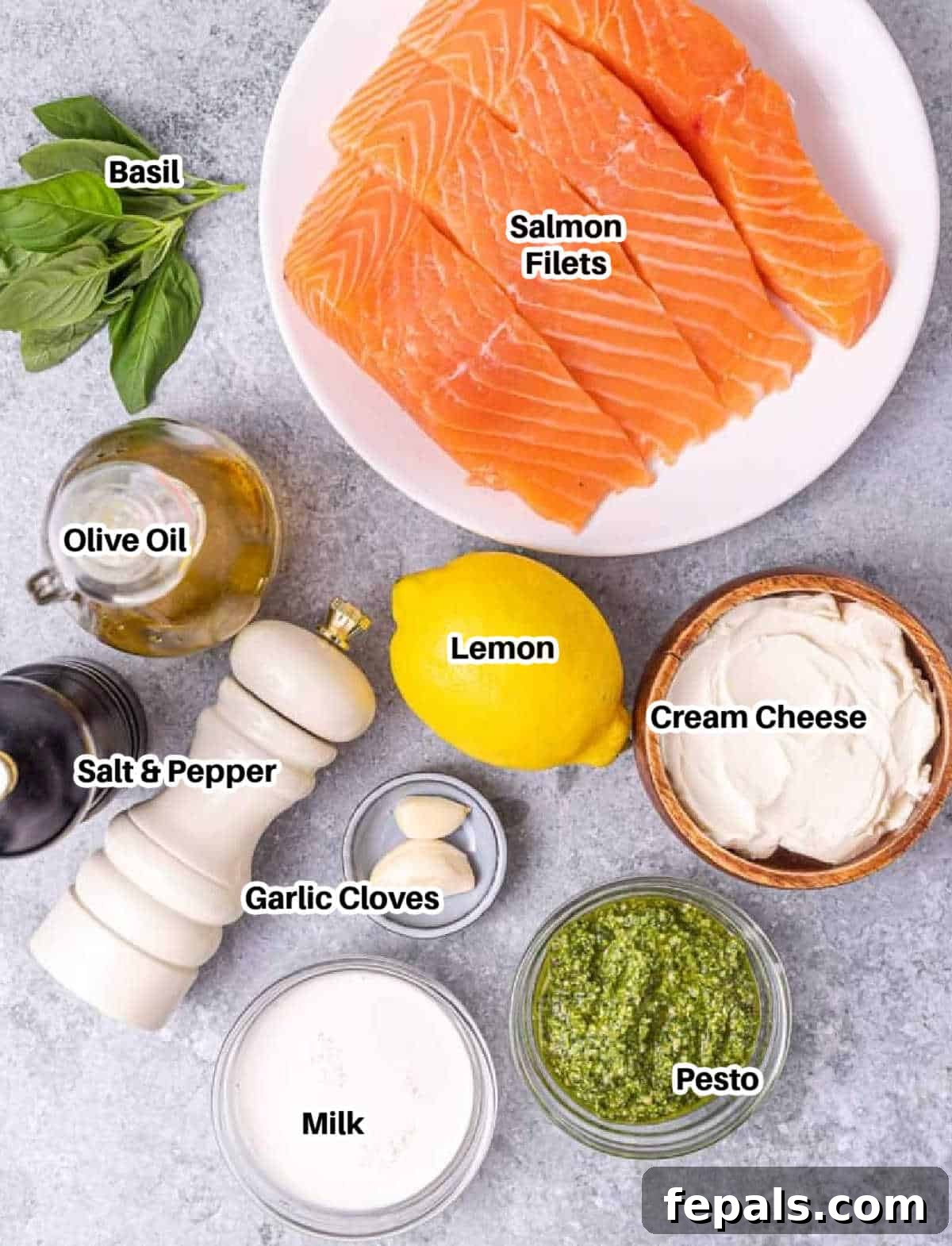 A flat lay photograph showcasing all the ingredients required for making creamy pesto salmon, neatly arranged.