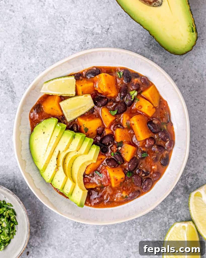 Sweet potato stew with black beans in a white bowl, garnished with fresh cilantro.