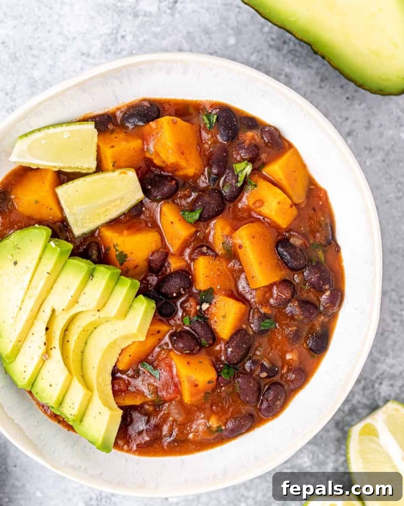 A close-up of a serving of sweet potato and black bean stew in a white bowl, ready to be enjoyed.