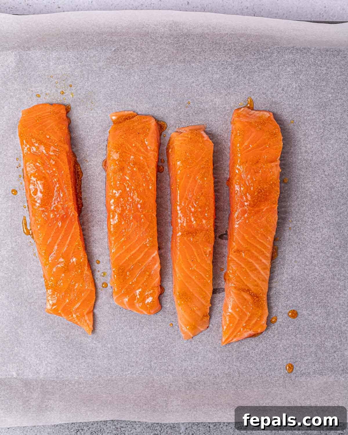Coating salmon filets in spices.