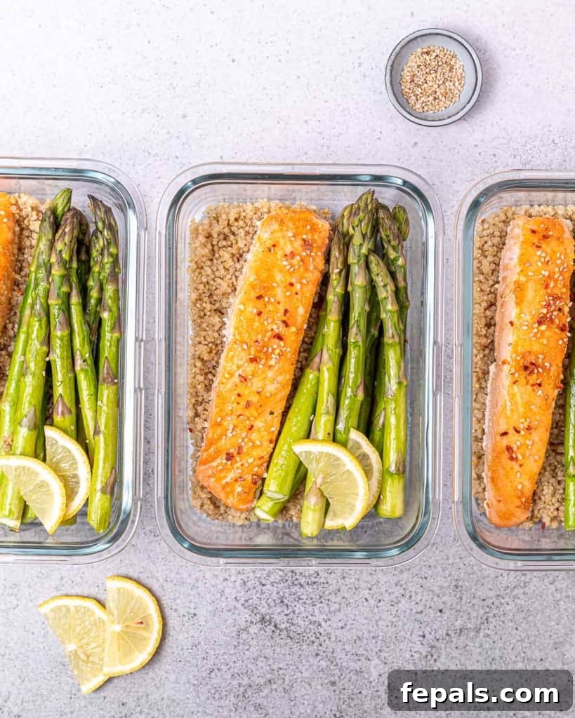 top view of 3 glass bowls with salmon asparagus and quinoa for meal prep