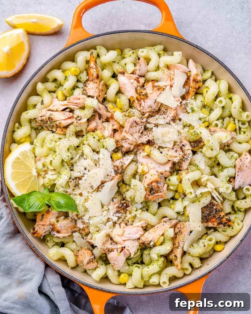 Savory Salmon Pesto Pasta 2 Pesto pasta in a skillet with flaked salmon and shaved parmesan.