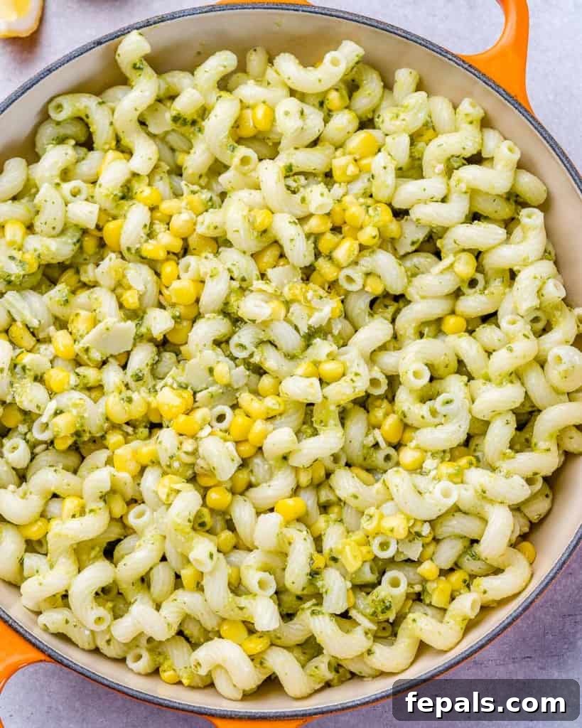 Savory Salmon Pesto Pasta 7 Pesto pasta with corn in a large pot.