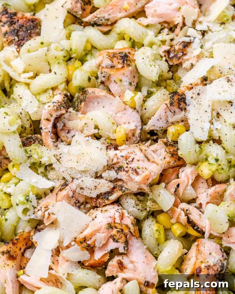 Savory Salmon Pesto Pasta 8 Salmon pesto pasta with corn and shaved parmesan cheese.