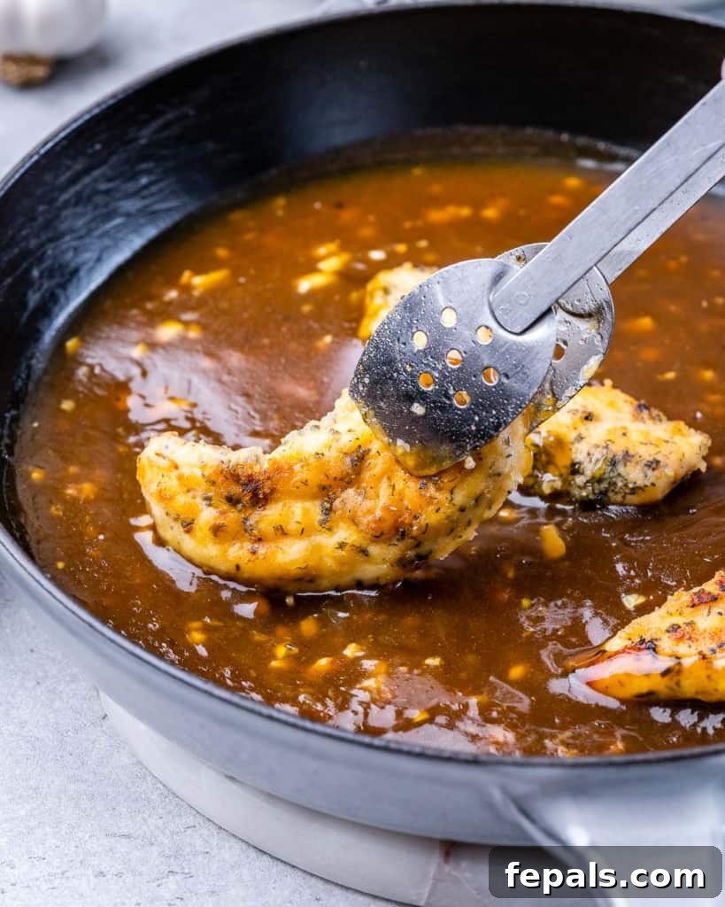Adding chicken tenderloin to a honey garlic sauce.