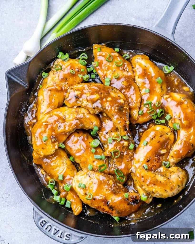 Honey garlic chicken tenderloins cooking in a skillet.