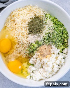 Mixing bowl filled with shredded cheddar cheese, eggs, chopped broccoli, and seasonings before combining.