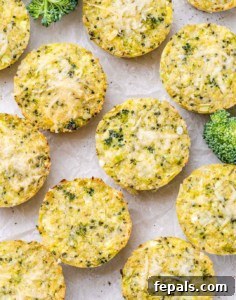 Freshly baked broccoli cheddar quinoa bites cooling on parchment paper, sprinkled with cheese.