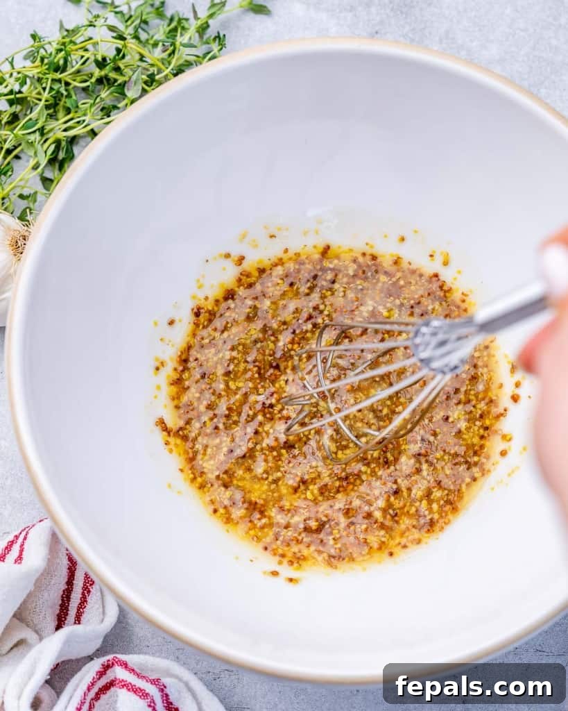 Golden Honey Mustard Carrots 6 Whisking honey mustard sauce ingredients in a white bowl.