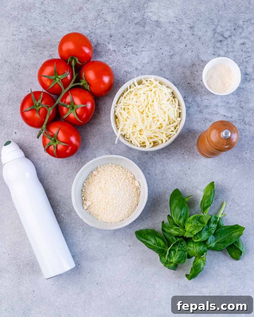 Fresh Roma tomatoes on the vine, bowls of shredded mozzarella and parmesan cheese, and a bunch of fresh basil.