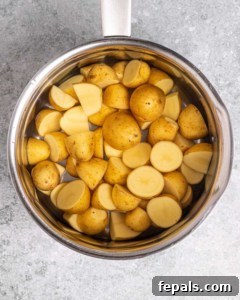 cooked halved potatoes in a pot.