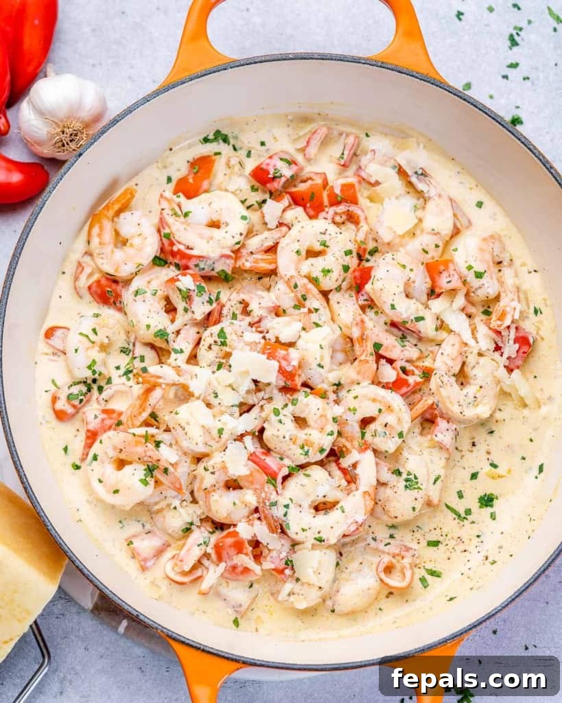 Luscious Garlic Shrimp Skillet Feast 2 Top view of sautéed shrimp in a creamy white sauce in an orange skillet, garnished with fresh parsley.