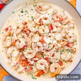 Luscious Garlic Shrimp Skillet Feast 12 top view of sauteed shrimp in a creamy white sauce in an orange skillet