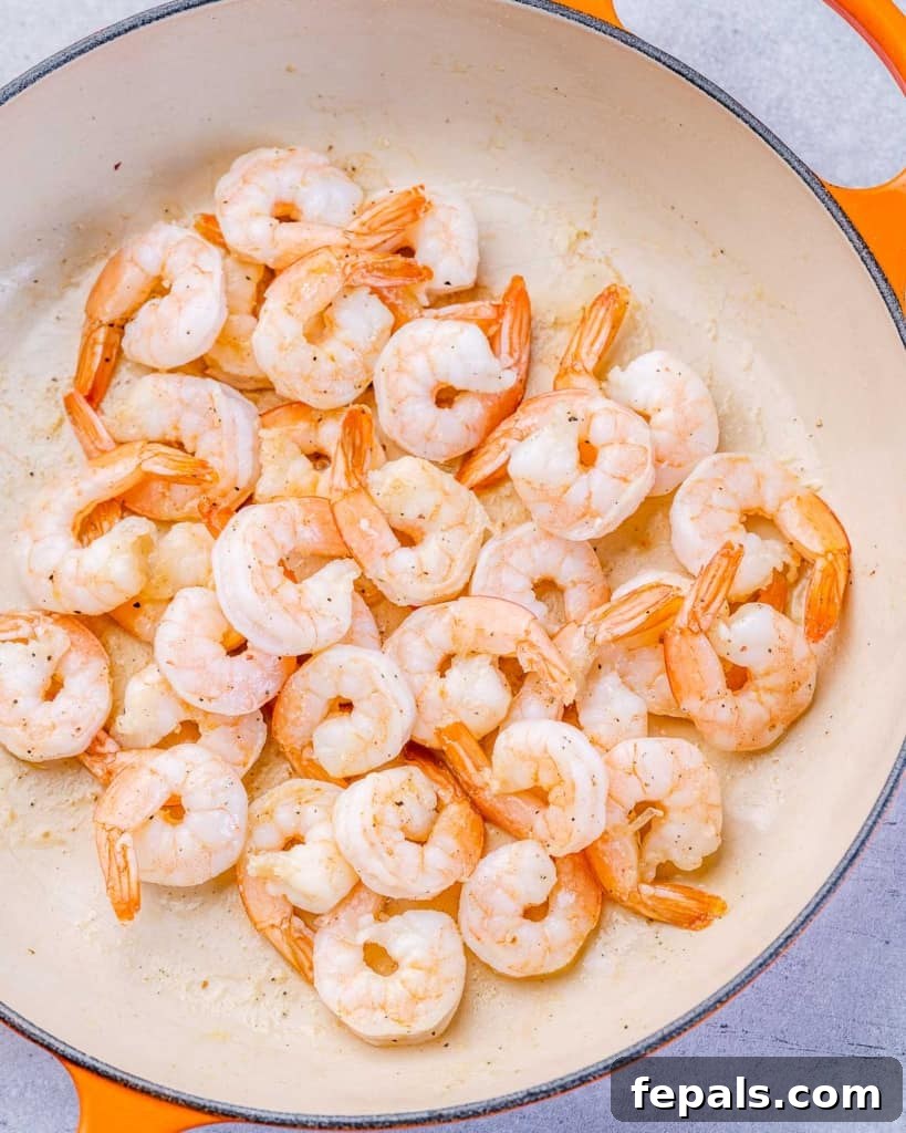 Luscious Garlic Shrimp Skillet Feast 5 Raw shrimp being sautéed in a skillet with olive oil.
