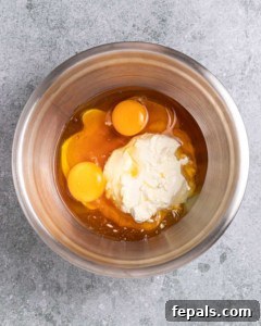 Combining eggs, honey and cream cheese in a large bowl.