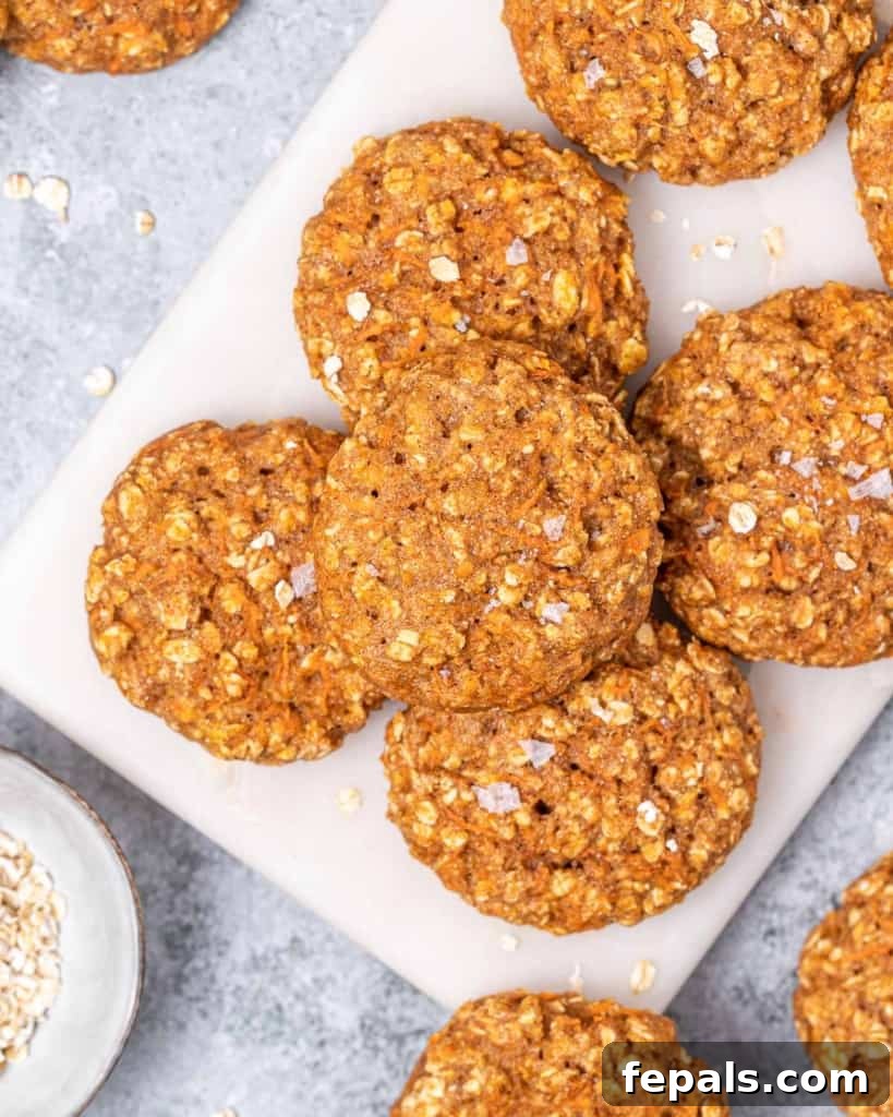 Top view stack of round carrot cake cookies on a board, showcasing their inviting texture and golden-brown hue.