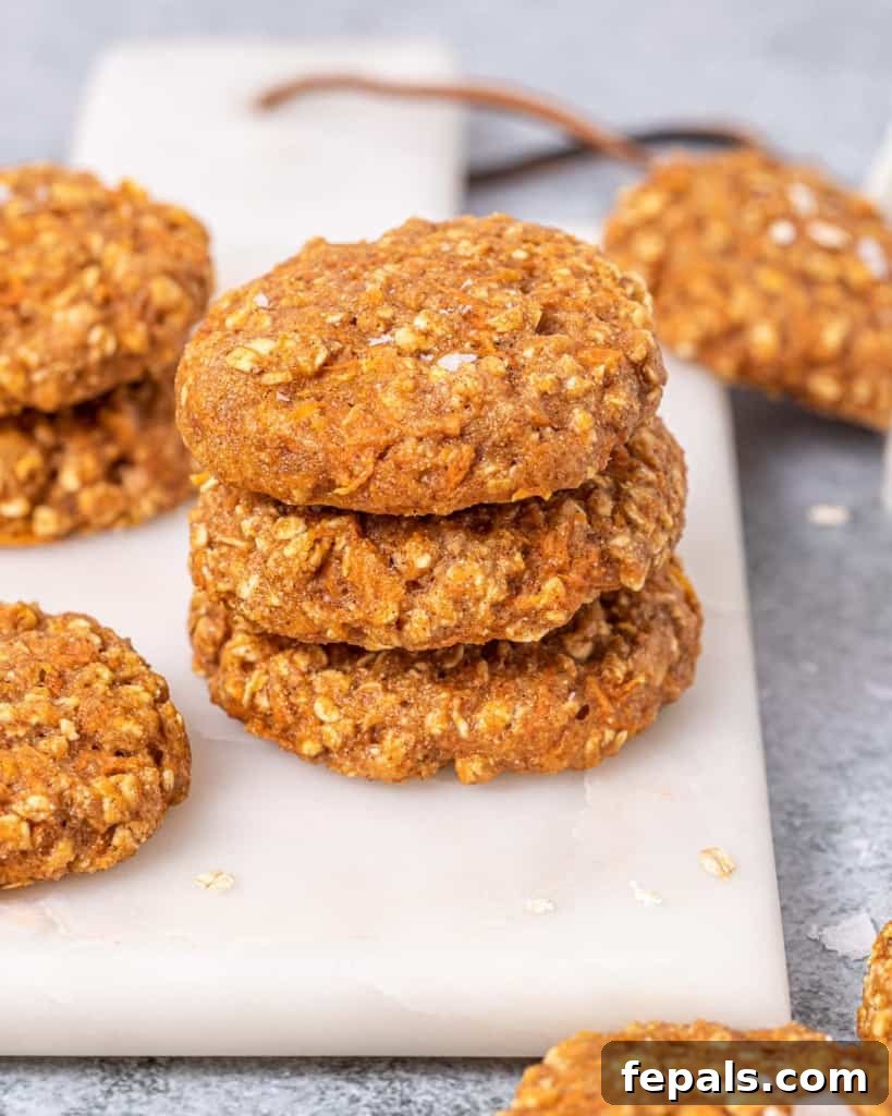 Three perfectly stacked carrot cake cookies, showcasing their soft texture and inviting appearance.