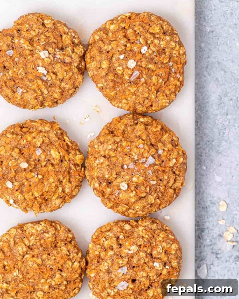 Top view of six delicious orange-colored carrot cake cookies arranged on a cutting board, ready to be served.