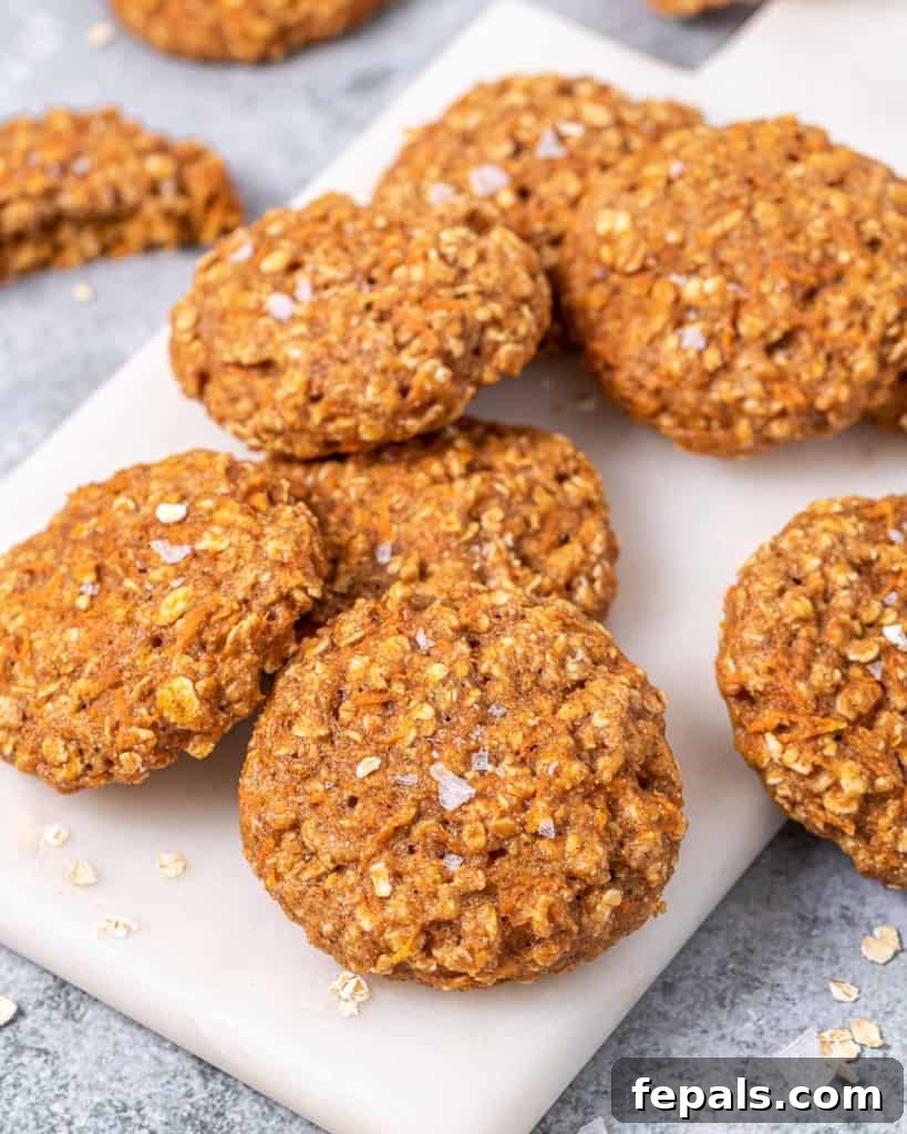 Close-up view of freshly baked carrot cake cookies, made with oats and carrots, arranged artfully on a cutting board.