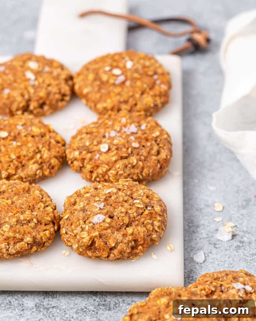 A neat line of freshly baked carrot cake cookies cooling on a cutting board, ready to be enjoyed.