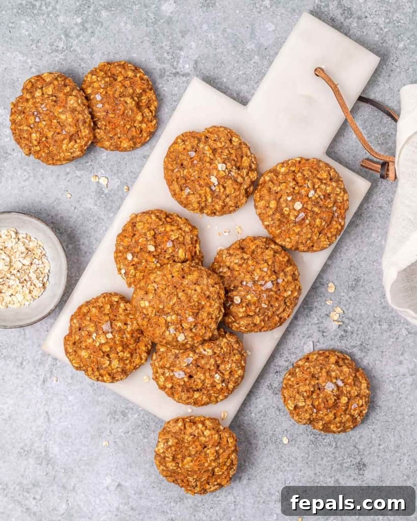 Top view of six perfectly round carrot cake cookies neatly arranged on a wooden cutting board, highlighting their inviting appeal.