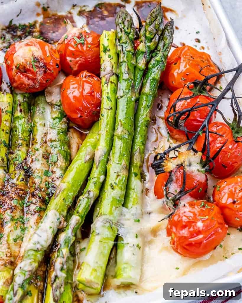 Balsamic asparagus served with cherry tomatoes on a white plate.