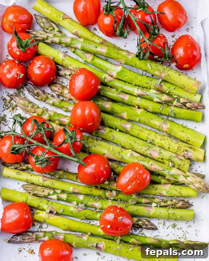 Cooking asparagus and cherry tomatoes on a sheet pan.
