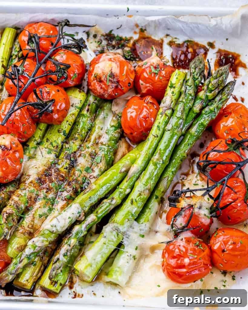 side shot of baked asparagus with tomatoes and drizzled with balsamic vinegar