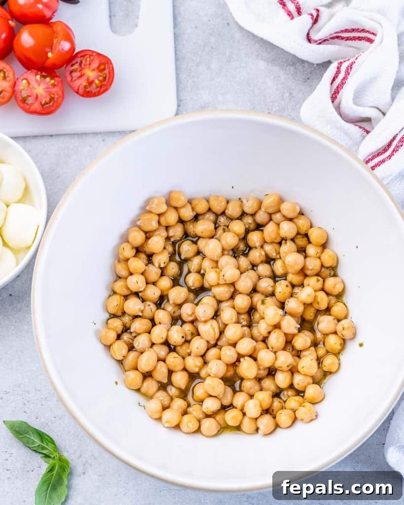 Classic Antipasto Salad 6 A generous portion of chickpeas nestled in a large white bowl, absorbing the flavors of the freshly prepared dressing.