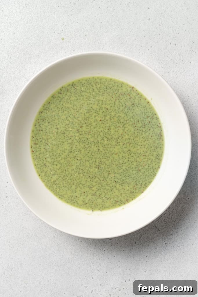 The chia seeds are fully combined with the matcha milk in a bowl, indicating the mixture is ready for the next stage of preparation.