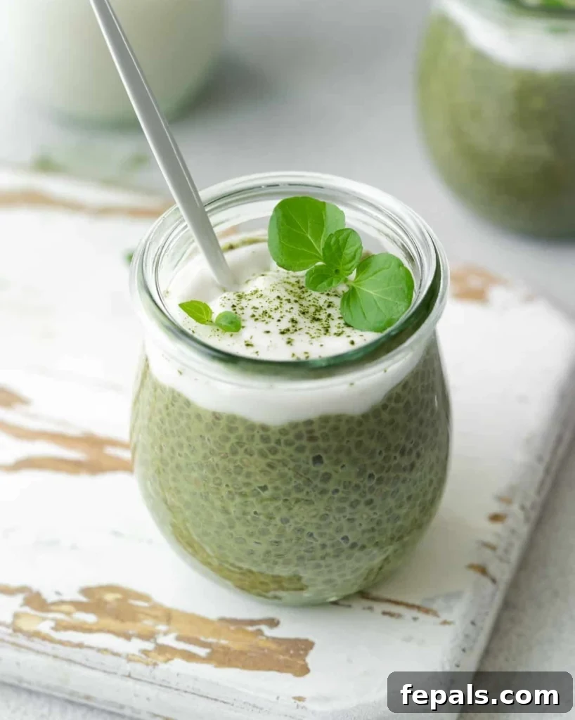 A spoon elegantly poised in a jar of verdant matcha chia pudding, hinting at the creamy texture and delicious taste of the healthy treat.