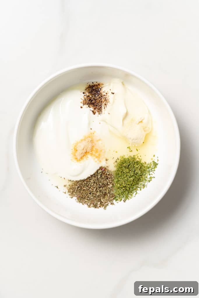 Plant-Powered Cobb Salad 5 Mayo, Greek yogurt and seasonings added to a white bowl.