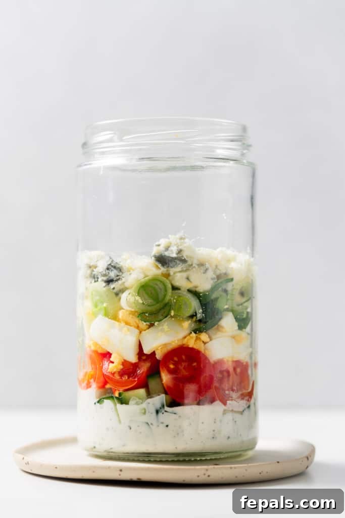Plant-Powered Cobb Salad 9 Layering salad ingredients in a glass jar.