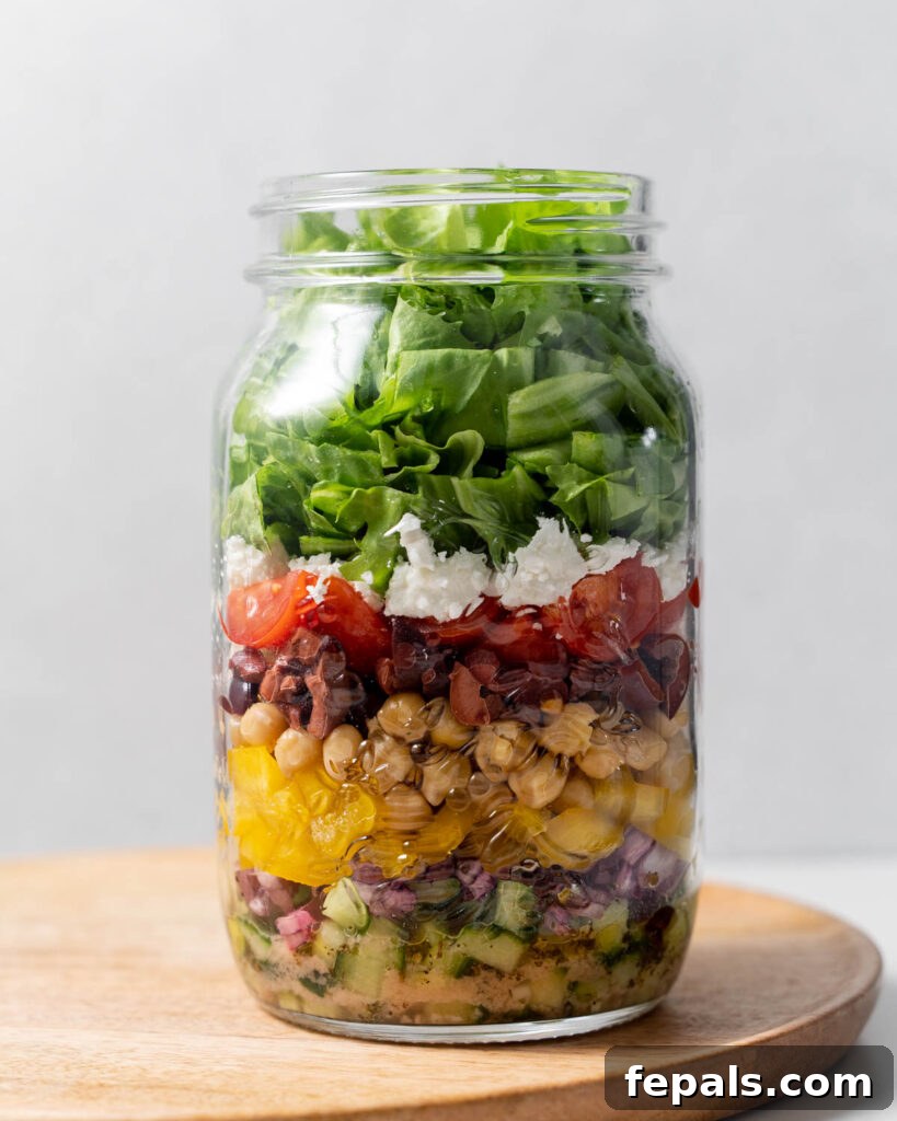 Layered Jar Salads 11 Ingredients to make greek salad added into a mason jar for meal prep
