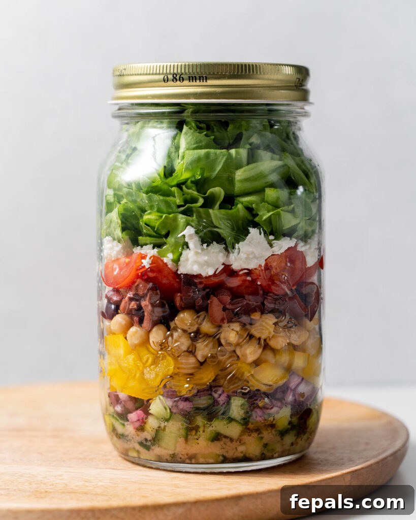 Layered Jar Salads 12 lid added over a jar filled with salad ingredients neal prepped to make Greek salad