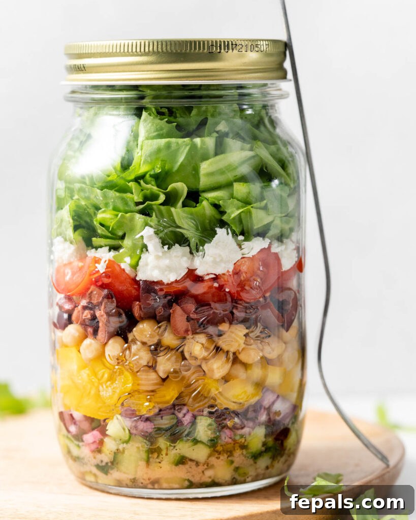 Layered Jar Salads 13 side shot of a greek Salad in a jar with spoon next to it on the right