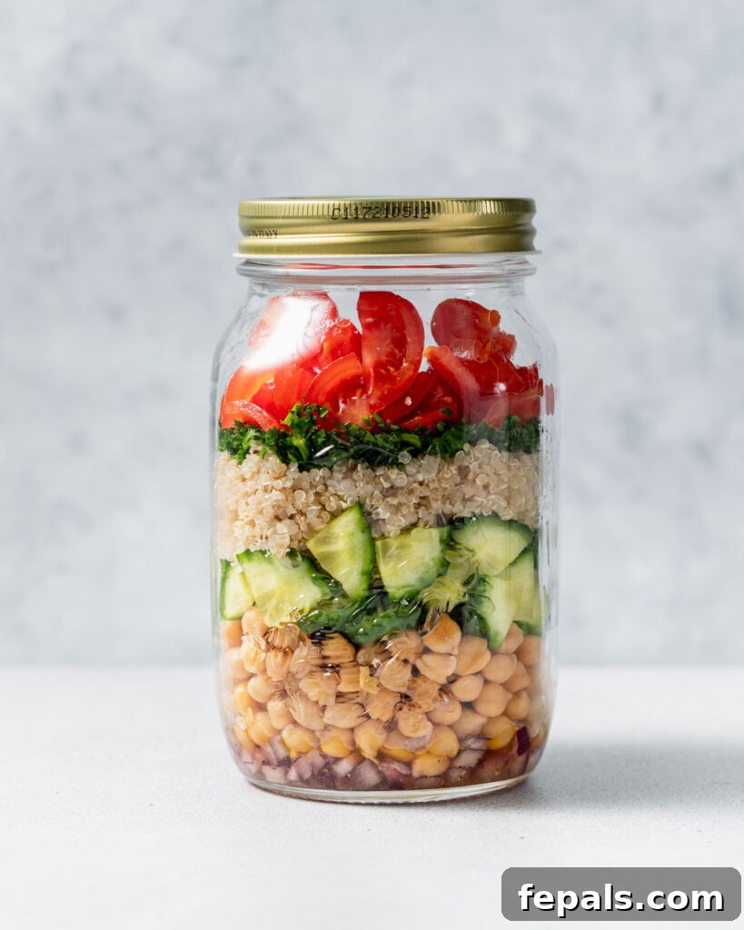 Refreshing Layered Chickpea Cucumber Jar 13 A chickpea quinoa jar salad with its lid securely placed, ready for storage or transport.