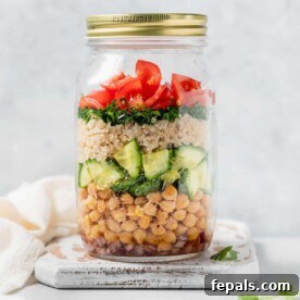 Side shot of quinoa and chickpea salad in a mason jar