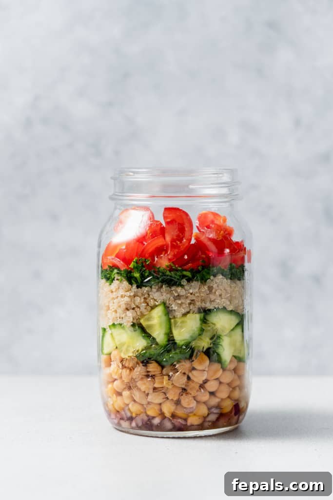 Refreshing Layered Chickpea Cucumber Jar 9 A vibrant chickpea quinoa salad jar, filled with colorful layers of ingredients and awaiting its lid.