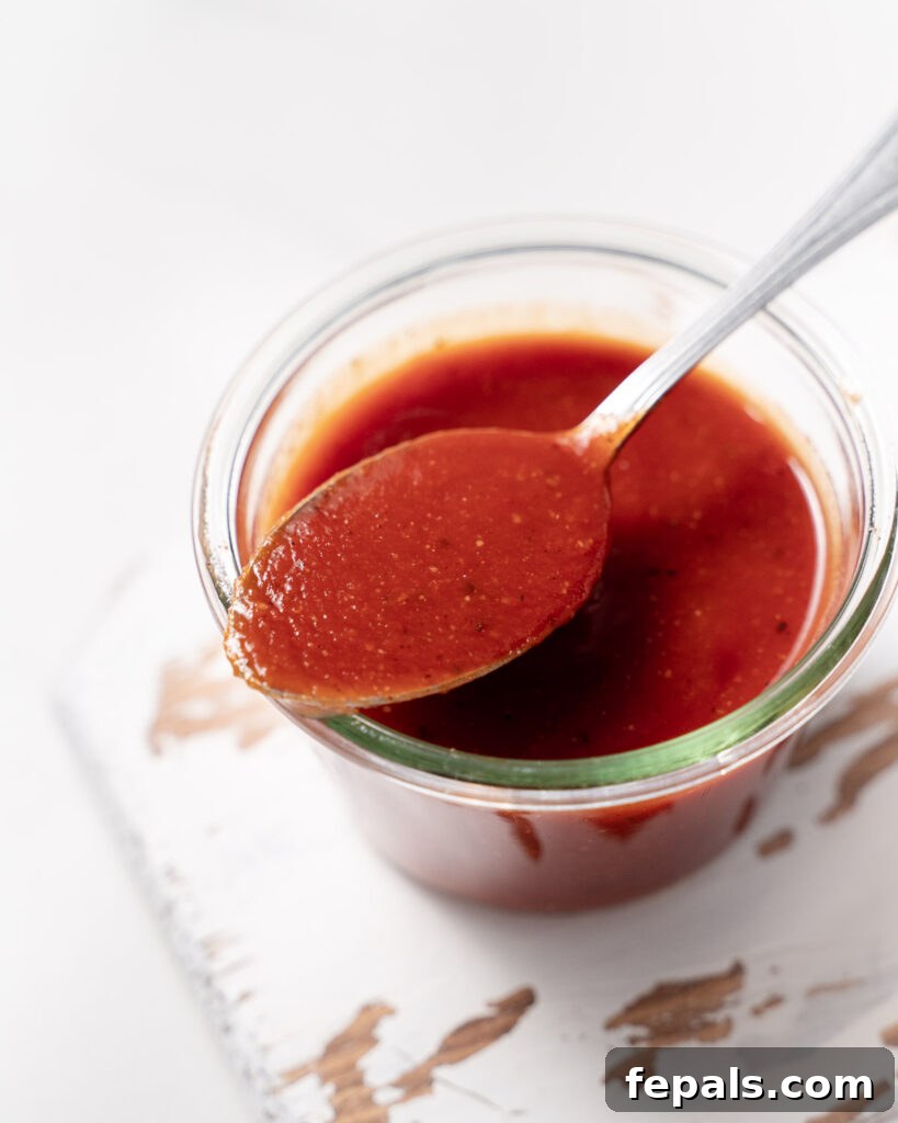 top view of a jar with bbq sauce and a spoonful over the jar