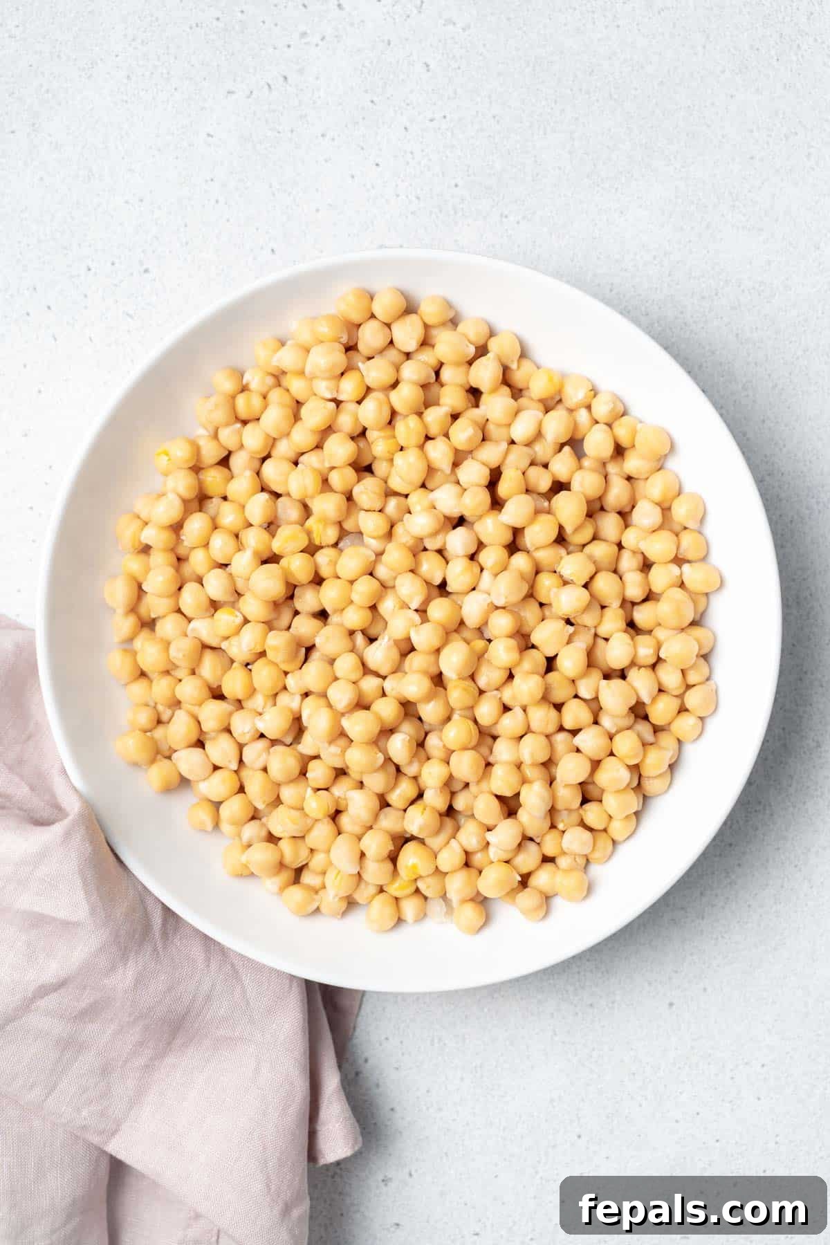 Your Guide to Perfectly Cooked Chickpeas 3 Cooked chickpeas in a white bowl.