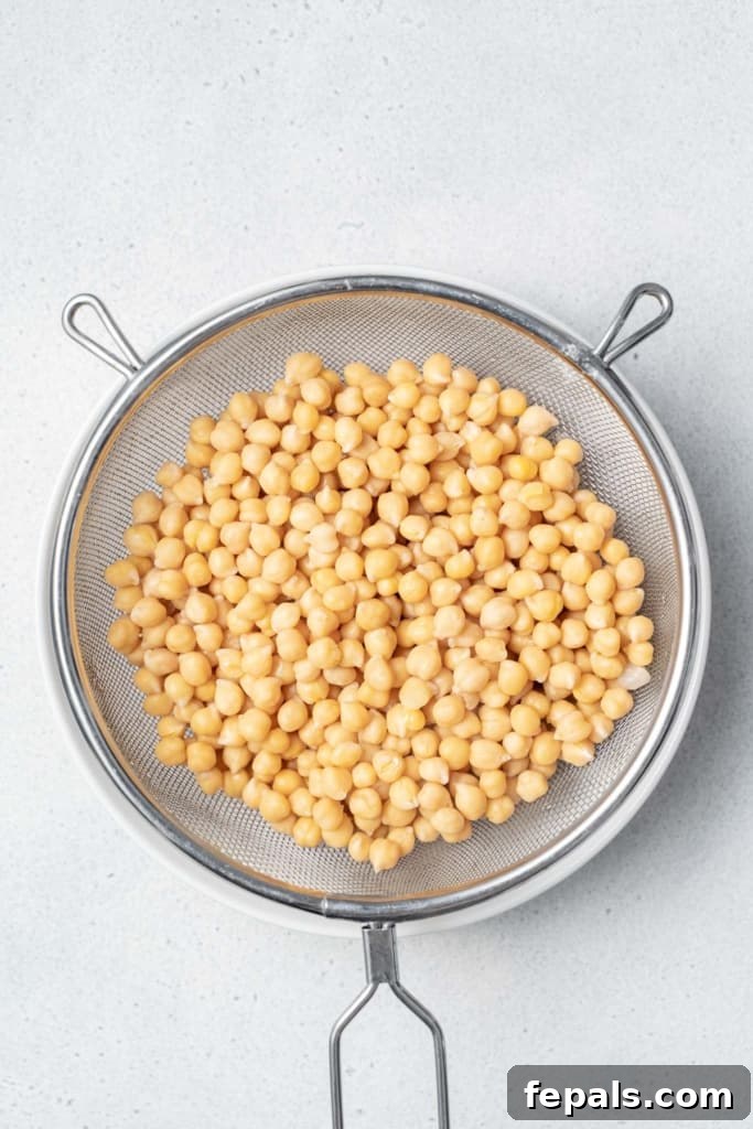 Your Guide to Perfectly Cooked Chickpeas 10 Draining chickpeas in a strainer.