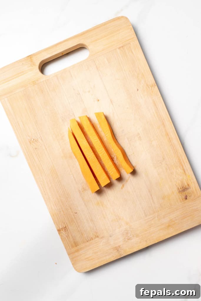 Long sticks of a sweet potato on a cutting board.